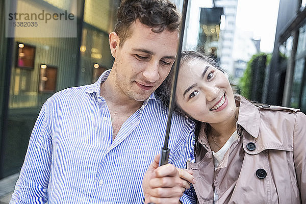 Porträt eines glücklichen Paares mit Regenschirm in Ginza  Tokio  Japan