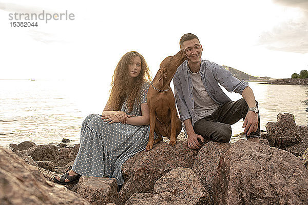 Junges Paar mit Hund am Strand