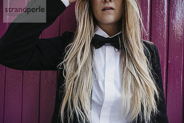 Blonde junge Frau mit schwarzer Krawatte und Blazer  Teilansicht