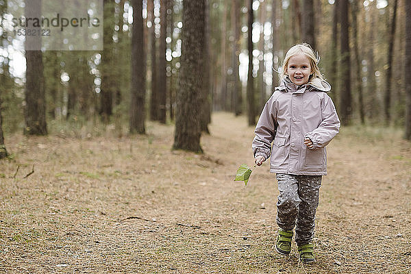 Porträt eines lächelnden kleinen Mädchens im Wald