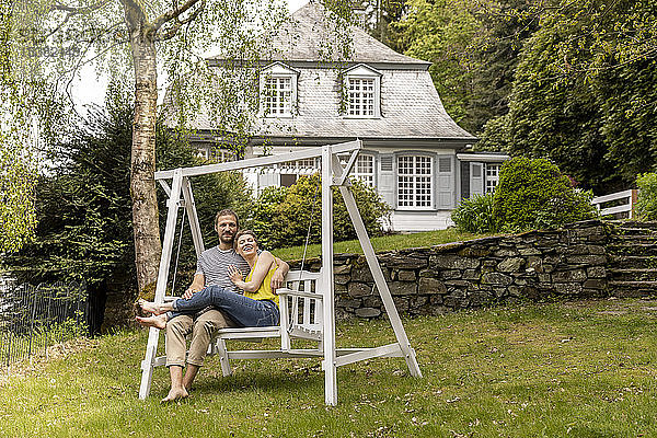 Entspanntes Paar im Garten seines Hauses