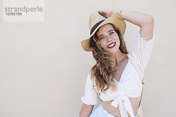 Porträt einer schönen lächelnden jungen Frau mit Hut