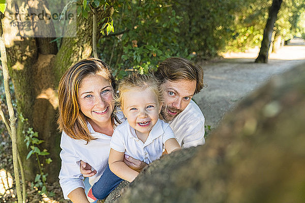 Porträt von Eltern mit kleiner Tochter in einem Park