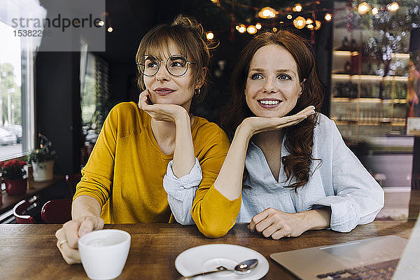 Zwei Freundinnen mit Laptop in einem Cafe