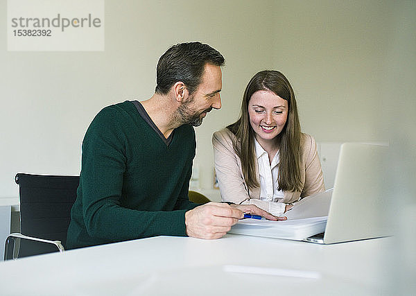 Geschäftsmann und Angestellter mit Laptop und Dokumenten  die am Schreibtisch im Büro arbeiten