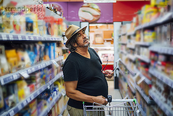 Älterer Mann beim Einkaufen in einem Supermarkt