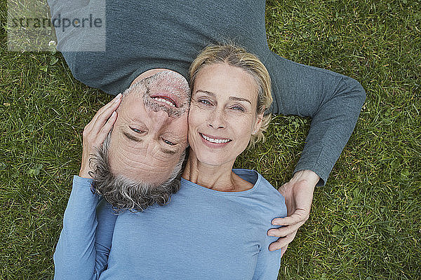 Draufsicht auf ein glückliches  reifes Paar  das im Gras liegt