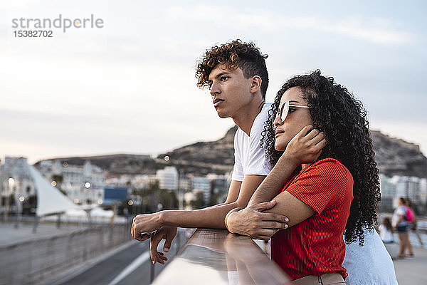 Junges Paar steht auf der Brücke und schaut auf die Aussicht