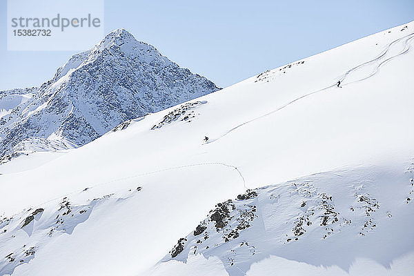 Zwei Skifahrer fahren in den Bergen bergab  Kühtai  Tirol  Österreich