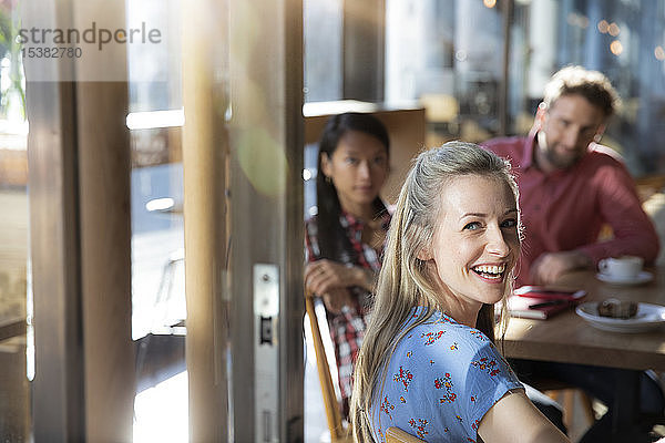 Porträt einer glücklichen Frau mit Freunden in einem Cafe