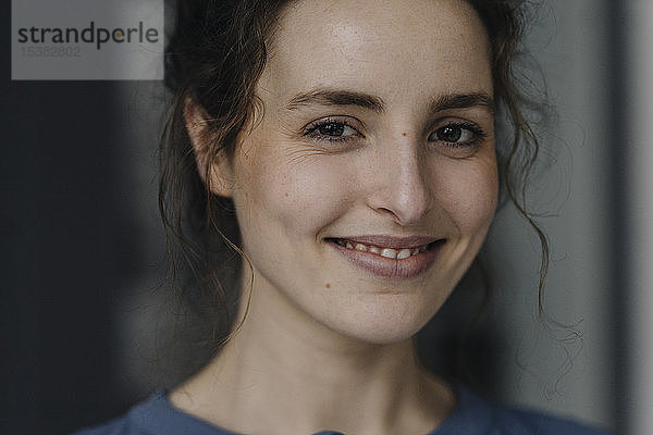 Porträt einer lächelnden jungen Frau mit braunen Augen
