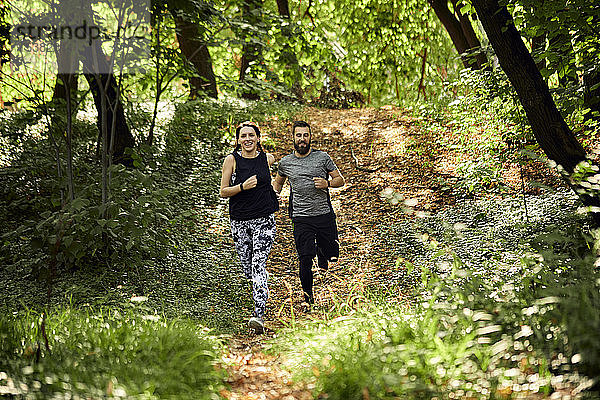 Sportliches Paar läuft auf Waldweg