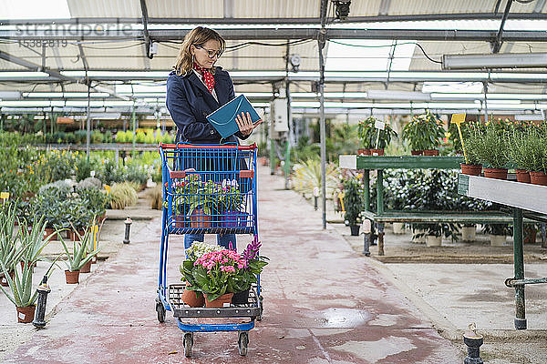 Frau kauft Blumen in der Gärtnerei