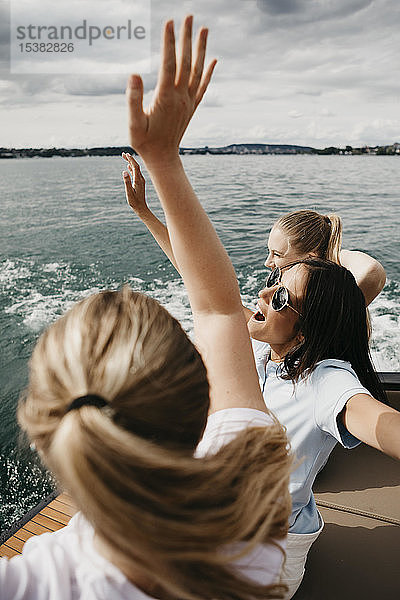 Fröhliche Freundinnen bei einer Bootsfahrt auf einem See