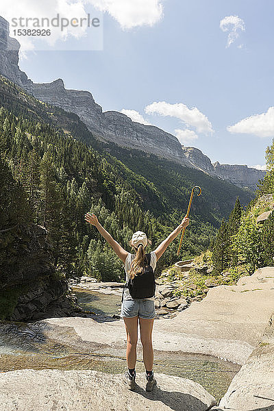 Rückansicht einer glücklichen Frau  die die Aussicht in den Bergen genießt  Ordesa-Nationalpark  Aragon  Spanien