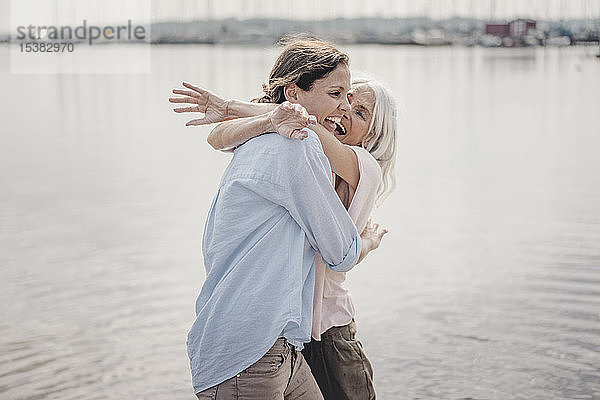 Mutter und Tochter verbringen einen Tag am Meer  lachen und umarmen sich