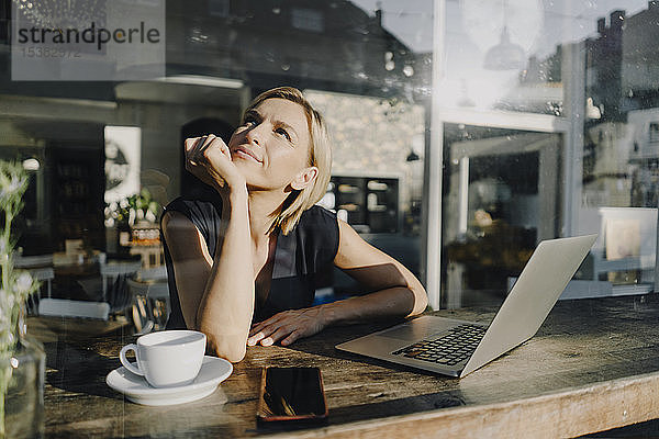 Blonde Frau mit Laptop in einem Café