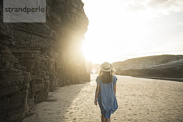 Frau beim Spaziergang am Strand der Kathedralen mit Felsen  Rückansicht  Galicien  Spanien