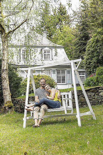 Glückliches Paar entspannt sich im Garten seines Hauses