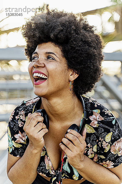 Porträt einer lachenden Afroamerikanerin mit Kopfhörern