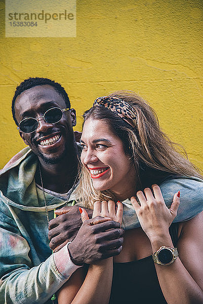 Porträt eines glücklichen Paares vor der gelben Wand