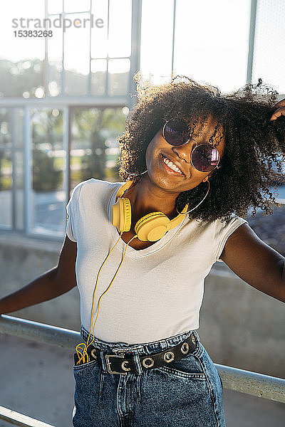 Porträt einer glücklichen jungen Frau mit Sonnenbrille