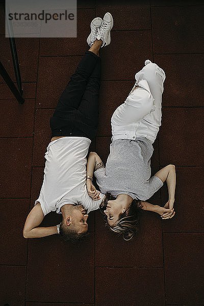 Auf dem Boden liegendes junges Paar  von oben