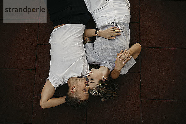 Auf dem Boden liegendes junges Paar  von oben