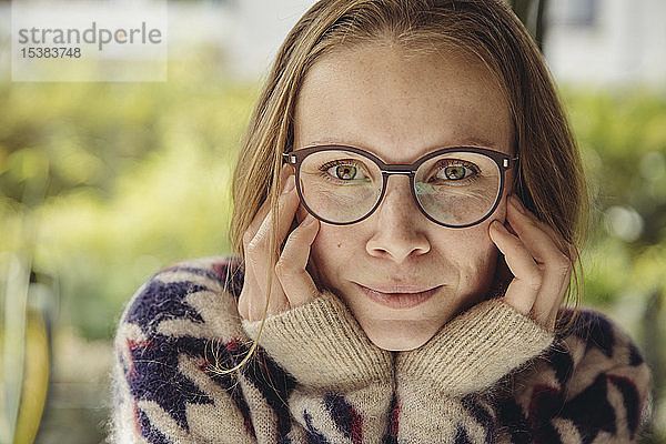 Porträt einer jungen Frau mit Brille und flauschigem Pullover