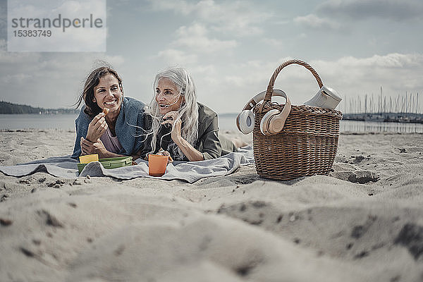 Mutter und Tochter machen ein Picknick am Strand