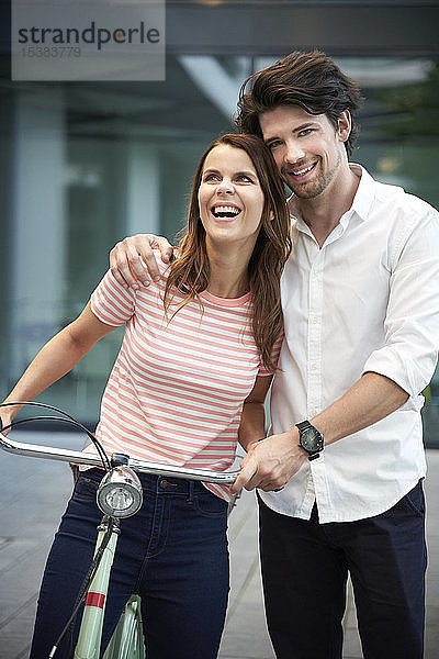 Glückliches Paar mit Fahrrad in der Stadt