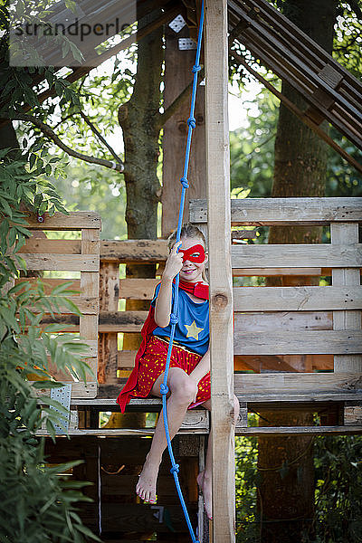 Superheldin spielt in einem Baumhaus