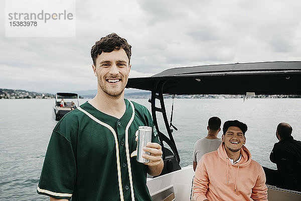 Glückliche Freunde bei einem Drink auf einer Bootsfahrt auf einem See