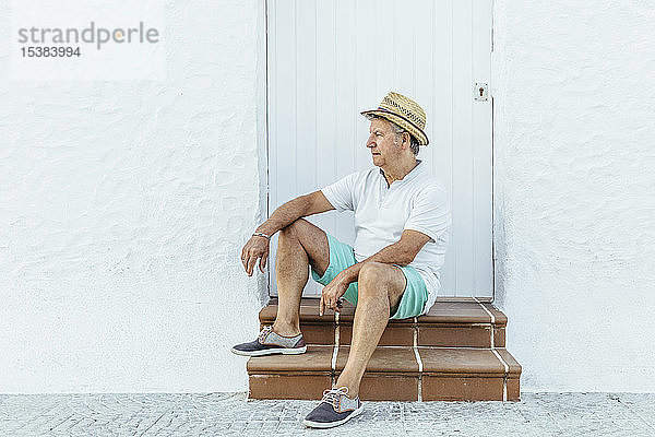 Älterer Tourist sitzt in einem Dorf auf der Treppe  El Roc de Sant Gaieta  Spanien