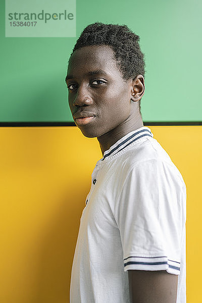 Porträt eines Teenagers vor grüner und gelber Wand