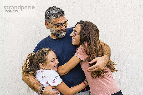 Vater umarmt zwei Töchter im Freien
