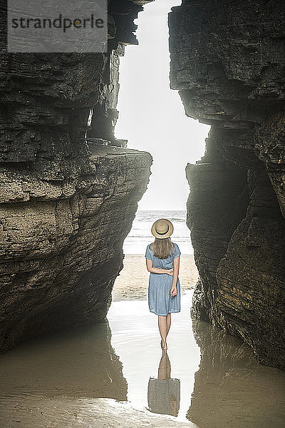 Am Strand der Kathedralen stehende Frau mit Felsen  Rückansicht  Galizien  Spanien