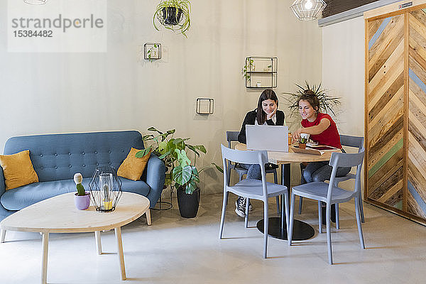 Zwei junge Frauen mit Laptop in einem Café