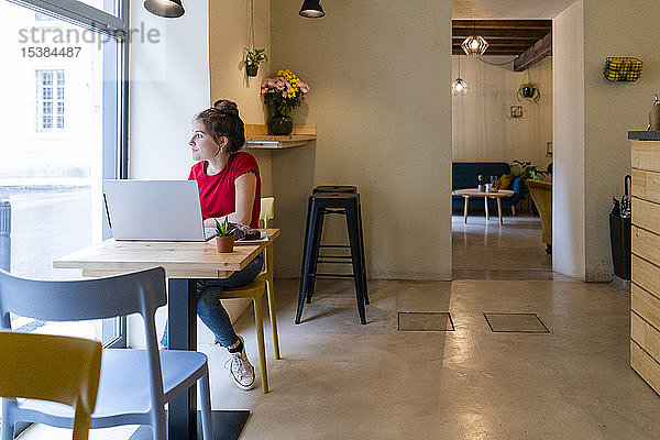 Junge Frau mit Laptop in einem Café