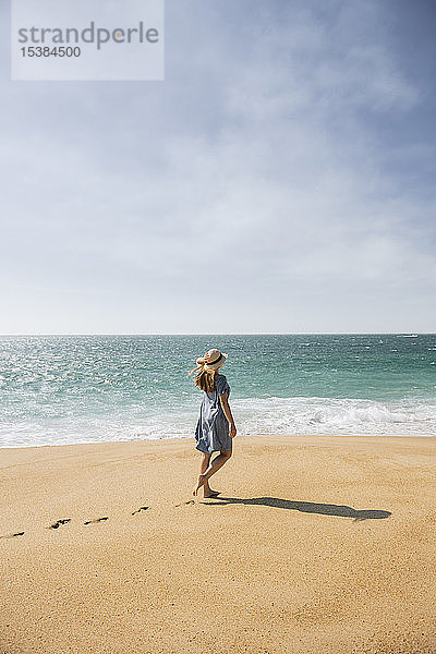 Rückansicht einer Frau  die am Strand spazieren geht  Nazare  Portugal