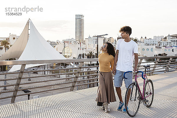 Junges Paar mit Fahrrad  zu Fuß in der Stadt