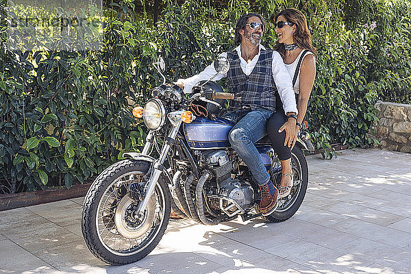 Glückliches reifes Paar auf einem Oldtimer-Motorrad