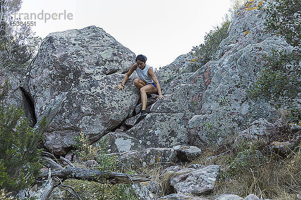 Junge Asiatin klettert in einer Felswand