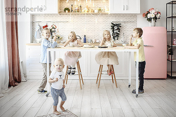 Fünf Kinder essen Kekse in der Küche