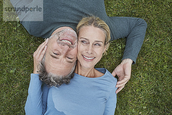 Draufsicht auf ein glückliches  reifes Paar  das im Gras liegt
