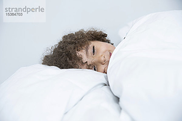 Bildnis eines im Bett liegenden Jungen mit lockigem Haar