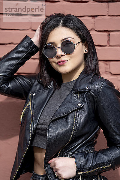 Bildnis einer jungen Frau mit Sonnenbrille und schwarzer Lederjacke