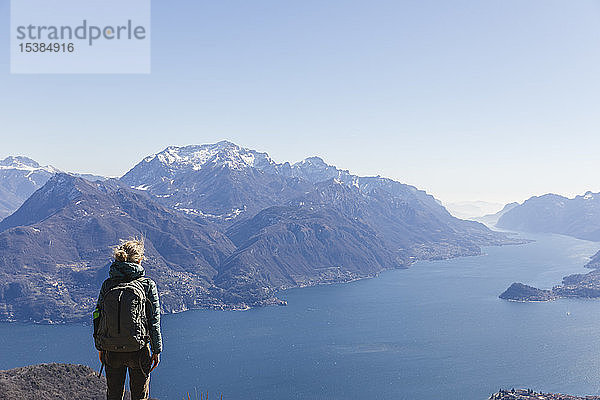 Italien  Como  Lecco  Frau auf einer Wanderung in den Bergen über dem Comer See  die die Aussicht genießt