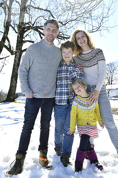Porträt einer glücklichen Familie auf einem Feld im Winter