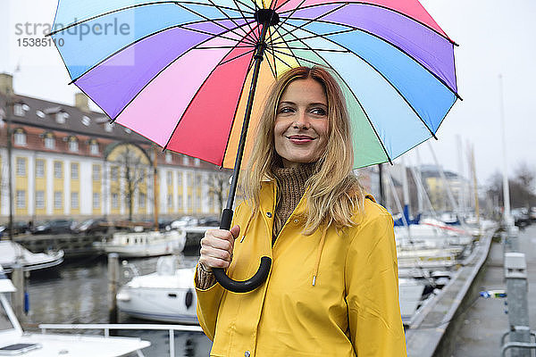 Dänemark  Kopenhagen  lächelnde Frau mit buntem Regenschirm im Stadthafen